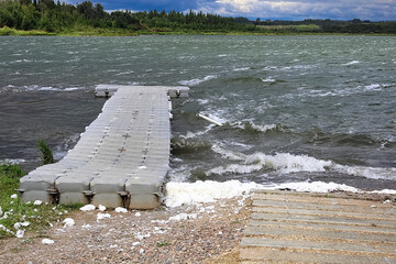 A floating dock on a white capped lake with waves