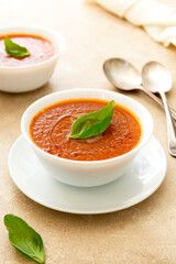 Gazpacho tomato soup, bowl of vegetable soup with basil leaves