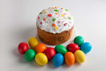 Easter cake and colorful Easter eggs on a white background. Homemade cake for celebrating Easter.