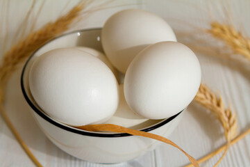White eggs in a bowl on a wooden table - 425904623