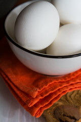 White eggs in a bowl on a wooden table - 425904625