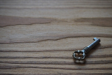 Iron key on a textured wooden table, background - 425904629
