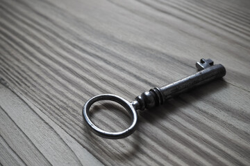 Iron key on a textured wooden table, background - 425904635