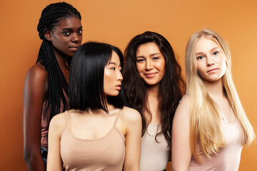 Obraz premium young pretty asian, caucasian, afro woman posing cheerful together on brown background, lifestyle diverse nationality people concept
