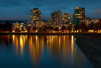 Fototapeta na wymiar English Bay Beach Night. Towers on Beach Avenue at twilight on English Bay, Vancouver.