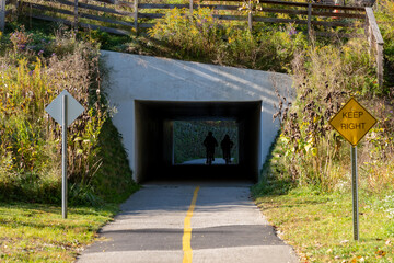 Fototapeta premium Cyclists Pass Through Tunnel on a Biking Path