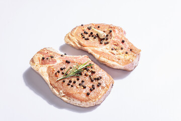 Two raw pork loin steaks isolated on white background