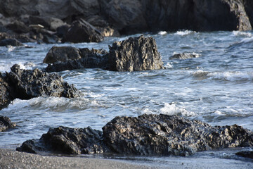 waves crashing on rocks in beach