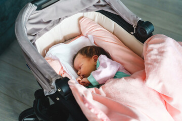 Close up on newborn caucasian baby sleeping in bed at home in stroller cradle - cute little infant...