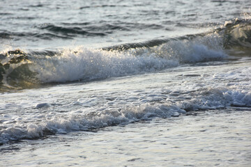 rough sea waves on a deserted beach at sunset
