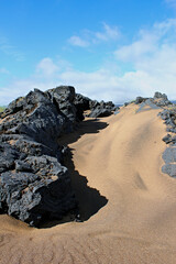Fototapeta na wymiar Rocks in sand on a beach