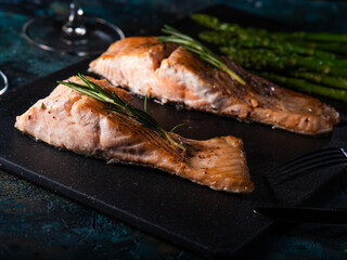 cooked slices of salmon with asparagus on a dark background. Recipes with seafood