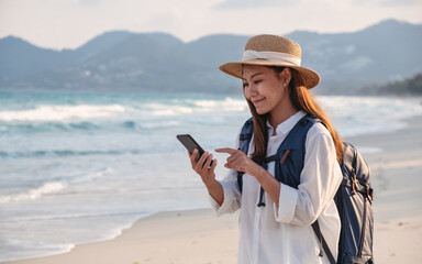 A female traveler holding and using mobile phone while traveling to the sea