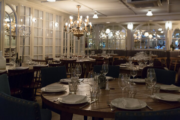 Fototapeta na wymiar Empty hall on stylish restaurant with serving wooden tables