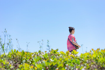三線を弾く日本人女性と青空