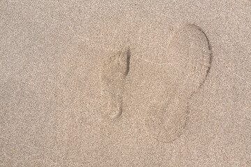 Fototapeta na wymiar 海水浴場の砂浜の子供と大人の足跡 