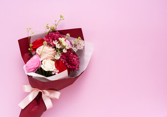 A bouquet of flowers placed on a pink background © m________k____