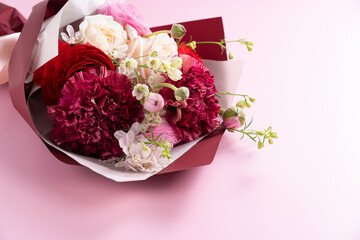 A bouquet of flowers placed on a pink background