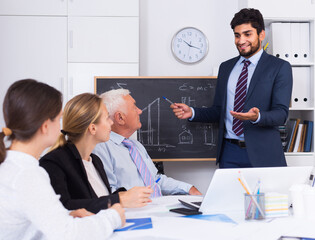 Fototapeta premium Office manager male is reading financial report to colleagues on meeting in the office.