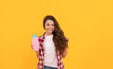 beauty. kid use shower gel. happy teen girl with shampoo bottle. shampooing hair in salon