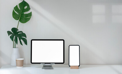 Mockup blank screen tablet and smartphone on white table with copy space.