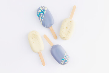 Blue and white cookie ice creams on a stick on white background