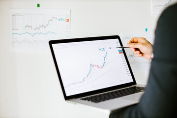 Fototapeta na wymiar Stock market price trend graph analysis. bitcoin price graph data trend analysis on laptop screen.