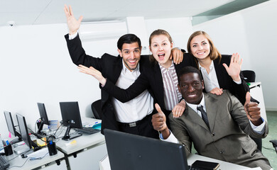 Successful multinational business team expressing satisfaction with teamwork in meeting room,...
