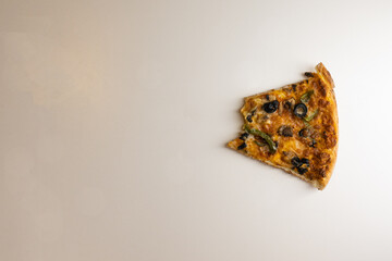 A biten slice of pizza on white background, top view