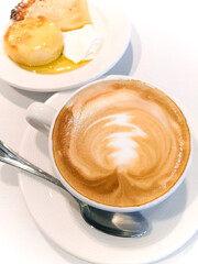 Delicious breakfast, Cup of cappuccino with pancakes with honey, top view, vertical photo