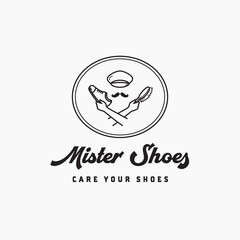 Hand holding shoes and brush for care and clean logo