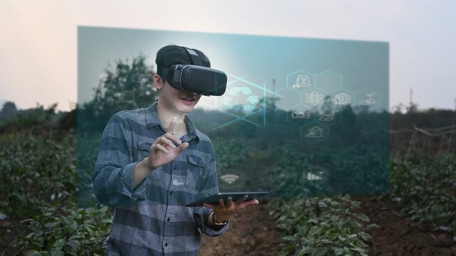 Futuristic farmer holding digital tablet and wearing visual reality glasses technology with futuristic augmented reality holograms for development agricultural products. Agriculture technology concept - Powered by Adobe