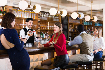 Portrait of positive smiling barman and happy cheerful glad people who are standing near bar...