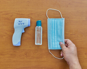 Equipo para protegerse contra COVID con un termómetro, gel antibacteriana, aerosol y mascarilla...