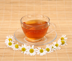 tea in a mug and chamomile flowers