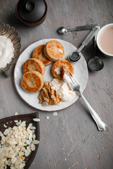 Cheesecakes made from melted cottage cheese with poppy seeds on a gray plate. Table setting for breakfast. Cooking dishes according to the old recipe.