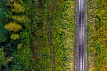 Poster railway track line through autumn forest, view from above © ako-photography