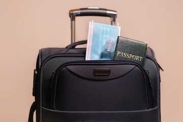 Medical face masks, passport , sanitizer,suitcase on a light background. Travel, vacation, Coronavirus, Covid-19, pandemic, quarantine,safe vacation.