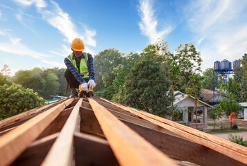 An old man carpenter works the roof truss on the roof truss construction site.