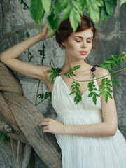 Woman in white dress and green leaves luxury nature model