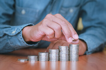 Close up part of hand Businessman is stacking coins. Saving and investment concept for the future.