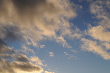 White and gray fluffy clouds on the blue sky. Wallpaper.