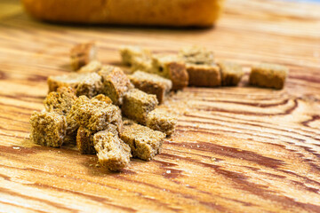 Fototapeta premium rye crackers on a wooden table in the background in a blur a loaf of bread