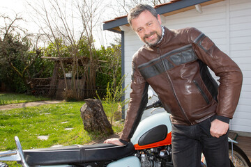 Handsome man happy smiling biker with vintage neo retro motorcycle