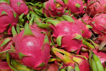 Close up a heap of fresh organic dragon fruits in a grocery store.