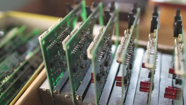 Slider shot video of a large green microcircuit with connectors in a military equipment factory. The concept of new technologies in production
