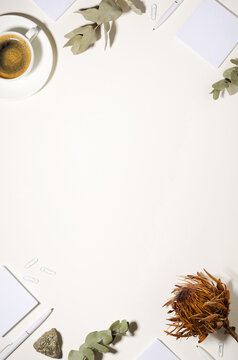Workplace with a cup of coffee, note sheets, pen and dried flowers