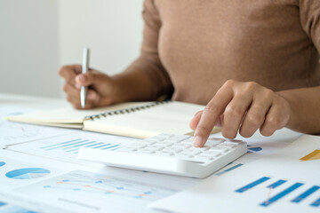 work from home, The hand of a woman who works in finance sits at his desk at home and calculates financial graphs showing the results of his investments, planning the steps of his business growth