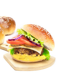Cheeseburger on a cutting board isolated on a white background. Hamburger with cheese. Burger isolated. Tasty dinner. Vertical orientation