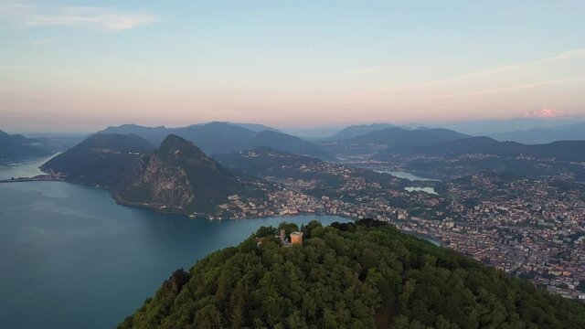 Aerial footage of the sunset over the Monte Bre overlooking the city and lake of Lugano in Canton Ticino in Switzerland. Shot with an orbit motion